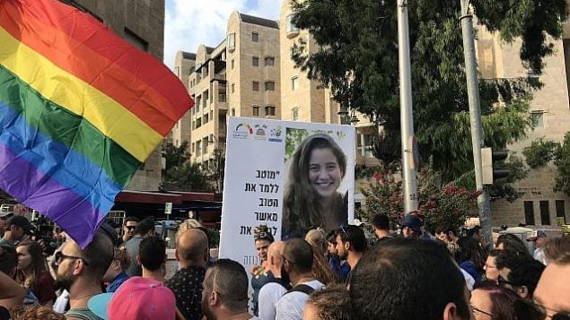 مشاركون في ’مسيرة الفخر’ في القدس يرفعون لافتة تحمل صورة شيرا بانكي (16 عاما)، التي قُتلت بيد متطرف حريدي في مسيرة الفخر التي أجريت في العاصمة في عام 2015، 2 أغسطس، 2018.  (Luke Tress/The Times of Israel)
