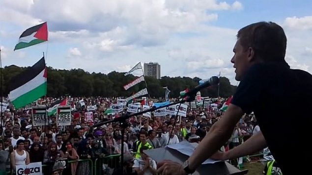يتحدث سيوماس ميلن إلى تظاهرة معادية لإسرائيل خلال "الجرف الصامد" عام 2014. (موقع YouTube) يتحدث سيوماس ميلن إلى تظاهرة معادية لإسرائيل خلال "الجرف الصامد" عام 2014. (موقع YouTube)