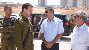رئيس القيادة الجنوبية للجيش الإسرائيلي جنرال هرتسل هاليفي، يسار وسط، يتحدث مع رئيس بلدية سديروت ألون دافيدي، يمين وسط، خلال زيارة إلى البلدة الجنوبية، التي تعرضت مرارًا وتكرارًا لإطلاق الصواريخ من قطاع غزة في أغسطس 9، 2018. (الجيش الإسرائيلي)