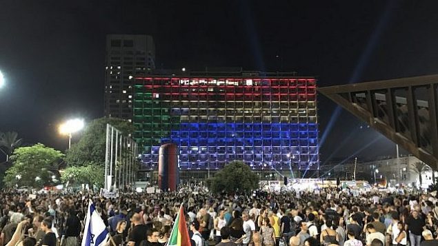 متظاهرون يلوحون بالأعلام الإسرائيلية والدرزية خلال مظاهرة في تل ابيب ضد قانون الدولة اليهودية، 4 اغسطس 2018 (Adam Rasgon/ Times of Israel staff)
