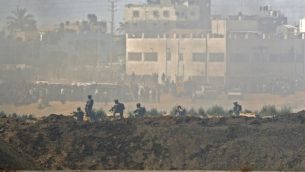 صورة تم التقاطها في 14 مايو، 2018 من كيبوتس ناحال عوز في جنوبي إسرائيل عبر الحدود مع غزة لجنود إسرائيليين ومتظاهرين فلسطينيين يحتشدون بالقرب من السياج الحدودي مع إسرائيل. (AFP/JACK GUEZ)