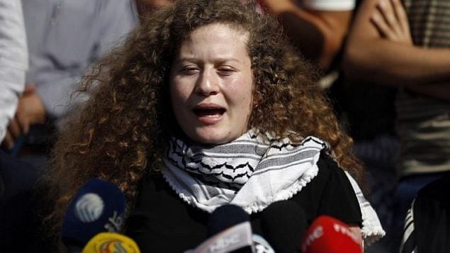 الفتاة الفلسطينية عهد التميمي تتحدث في مؤتمر صحفي عُقد على مشارف قرية النبي صالح في 29 يوليو، 2018، بعد قضائها فترة عقوبة بالسجن لمدة 8 أشهر لقيامها بصفع جندي إسرائيلي. (AFP Photo/Abbas Momani)