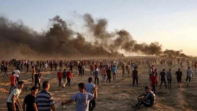 متظاهرون فلسطينيون يجتمعون أثناء مظاهرة على امتداد السياج الحدودي الإسرائيلي شرق مدينة غزة في 21 سبتمبر 2018 حيث تتصاعد أعمدة الدخان من الإطارات المحترقة في الخلفية. (AFP/Said Khatib) متظاهرون فلسطينيون يجتمعون أثناء مظاهرة على امتداد السياج الحدودي الإسرائيلي شرق مدينة غزة في 21 سبتمبر 2018 حيث تتصاعد أعمدة الدخان من الإطارات المحترقة في الخلفية. (AFP/Said Khatib)