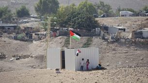 طفلات فلسطينيات يقفن إلى جانب حاوية شحن تم وضعها حديثا في قرية الخان الأحمر البدوية، 11 سبتمبر، 2018.   (AP Photo/Majdi Mohammed)