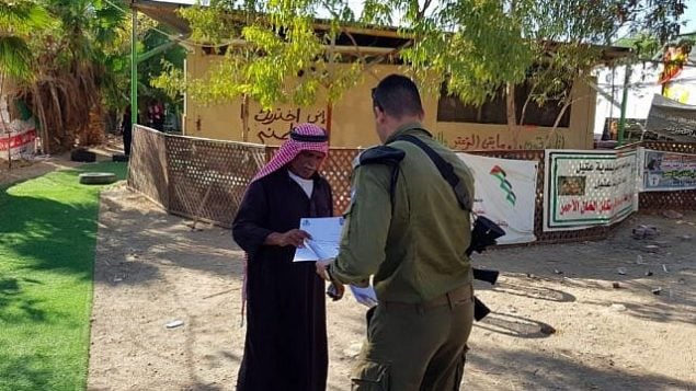 يقوم مسؤول في الإدارة المدنية بتسليم إشعار بشأن الهدم الوشيك للخان الأحمر إلى أحد سكانها في 23 سبتمبر 2018. (الإدارة المدنية)