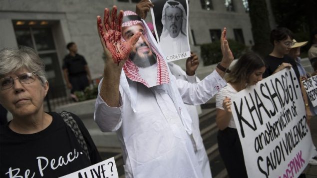 متظاهرا مرتديا قناع بشكل وجه ولي العهد السعودي محمد بن سلمان مع ايدي ملطخة بالدماء، في احتجاج امام السفارة السعودية في واشنطن، مطالبة بالعدالة للصحفي السعودي المفقود جماش خاشقجي، 8 اكتوبر 2018 (Jim Watson/AFP)