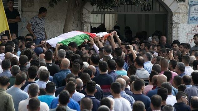 فلسطينيون يشيعون جثمان عائشة الرابي (48 عاما) ، التي توفيت متأثرة بجراحها نتيجة هجوم رشق حجارة تعرضت اليه مع زوجها خلال سفرهم بسيارة، في قرية بديا في الضفة الغربية، 13 اكتوبر 2018 (JAAFAR ASHTIYEH / AFP)