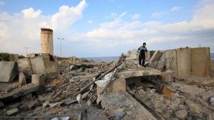 رجل فلسطيني يمشي فوق الأنقاض في أعقاب غارة جوية إسرائيلية بالقرب من مدينة رفح في جنوب قطاع غزة في أعقاب سقوط صارو خ على منزل في مدينة بئر السبع  الإسرائيلية، 17 أكتوبر، 2018. (SAID KHATIB / AFP)