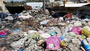قمامة متراكمة على جانب الشارع في حي وادي الجوز في القدس في 23 سبتمبر، 2018. (آدم راسغون / تايمز أوف إسرائيل)