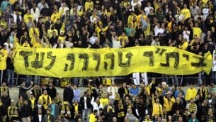 مشجعو نادي كرة القدم بيتار القدس يحملون لافتة كُتب عليها ’بيتار طاهر إلى الأبد’، 26 يونيو ،2013. (Flash90)