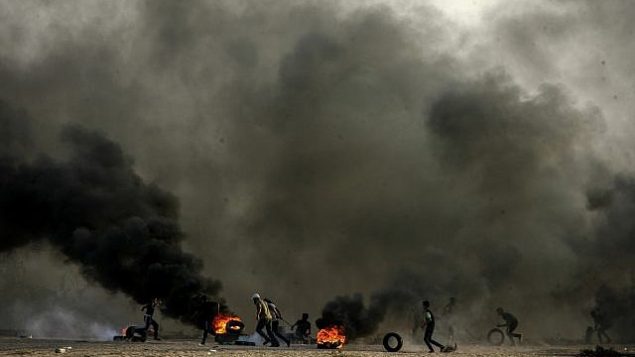فلسطينيون يشعلون إطارات في احتجاجات خلال "مسيرة العودة" على حدود غزة-إسرائيل في رفح، قطاع غزة في 12 أكتوبر، 2018. (Abed Rahim Khatib/Flash90) فلسطينيون يشعلون إطارات في احتجاجات خلال "مسيرة العودة" على حدود غزة-إسرائيل في رفح، قطاع غزة في 12 أكتوبر، 2018. (Abed Rahim Khatib/Flash90)