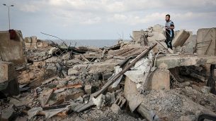 فلسطينيون يسيرون على أنقاض مبنى في أعقاب غارة جوية إسرائيلية في محيط مدينة رفح في جنوب قطاع غزة في 17 أكتوبر، 2018.  (Abed Rahim Khatib/ Flash90)