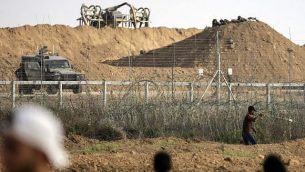 فلسطيني يستخدم المقلاع لإلقاء حجارة باتجاه القوات الإسرائيلي على الجانب الآخر من السياج الحدودي خلال مواجهات حدودية مع إسرائيل في شرق مدينة غزة، 13 يوليو، 2018. (AFP PHOTO / MAHMUD HAMS)