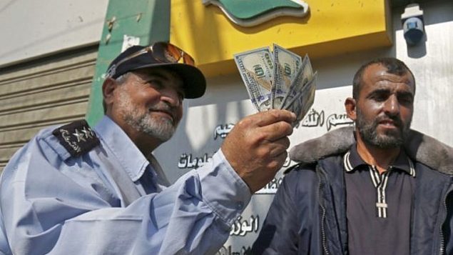 فلسطيني يعرض أمواله بعد تلقي راتبه في رفح جنوب قطاع غزة في 9 نوفمبر 2018. (Said Khatib/AFP)