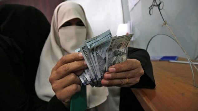 امرأة فلسطينية تتلقى راتبها في رفح جنوب قطاع غزة في 9 نوفمبر 2018. (Said Khatib/AFP)