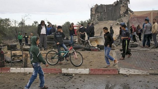 فلسطينيون يقفون إلى جانب حطام مبنى،  ورد أنه دُمر  غارة جوية إسرائيلية في خان يونس في جنوب قطاع غزة، 12 نوفمبر، 2018. (S