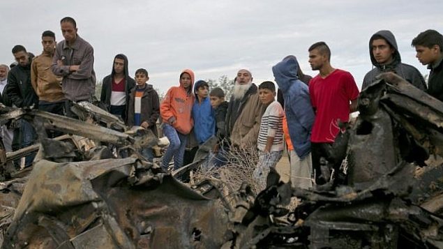 فلسطينيون يقفون بالقرب من مركبة، يفترض ان عناصر القوات الخاصة الإسرائيلية استخدموها خلال عملية في غزة، وتم تدميرها في غارة جوية إسرائيلية في خان يونس، جنوب قطاع غزة، 12 نوفمبر، 2018. (Photo by SAID KHATIB / AFP)