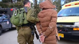 توضيحية: جندي إسرائيلي يعتقل فلسطينيا في مداهمة في مدينة نابلس في الضفة الغربية، 8 مارس، 2018. (IDF Spokesperson)