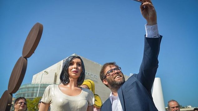 عضو الكنيست أورن حزان يقوم بإلتقاط صورة ’سلفي’ مع تمثال لوزيرة الثقافة الإسرائيلية ميري ريغيف في ميدان ’هابيما’ في تل أبيب، 8 نوفمبر، 2018.  Yossi Zeliger/Flash90)