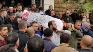 أفراد عائلة يحملون جثمان محمود أبو عصبة في مقبرة في حلحول، 14 نوفمبر، 2018. (Adam Rasgon/ Times of Israel)