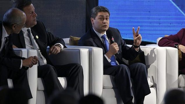 رئيس هندوراس، خوان أورلندو هرنانديز، يتكلم خلال منتدى اقتصادي في إطار القمة الإيبيرية الأمريكية السادسة والعشرين في أنتيغوا، غواتيمالا، 15 نوفمبر، 2018. (AP Photo/Moises Castillo) رئيس هندوراس، خوان أورلندو هرنانديز، يتكلم خلال منتدى اقتصادي في إطار القمة الإيبيرية الأمريكية السادسة والعشرين في أنتيغوا، غواتيمالا، 15 نوفمبر، 2018. (AP Photo/Moises Castillo)