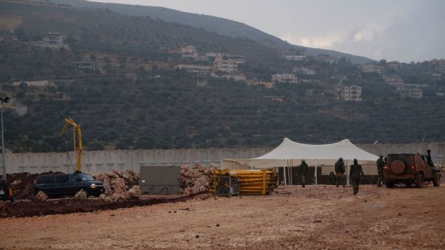 جنود اسرائيليون بالقرب من مدخل نفق تقول اسرائيل ان حزب الله حفره من جنوب لبنان نحو بستان تفاح يقع جنوب بلدة المطلة الإسرائيلية، 19 ديبسمبر 2018 (Judah Ari Gross/Times of Israel)