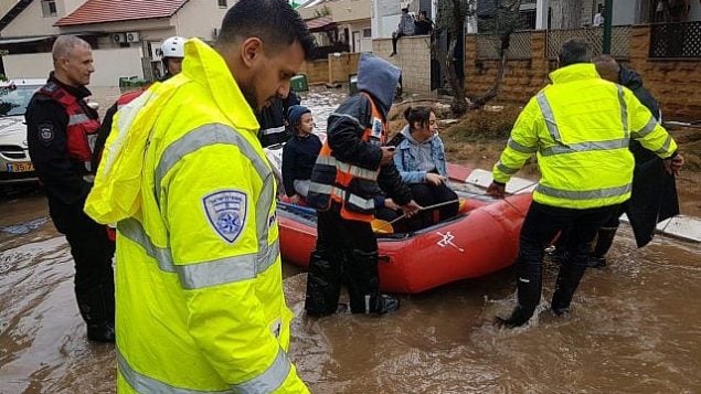 رجال الإنقاذ يستخرجون الإسرائيليين من منازلهم التي غمرتها الفيضانات في أحيعيز بوسط إسرائيل، بعد سقوط أمطار غزيرة على البلاد في 7 ديسمبر 2018 (الشرطة الإسرائيلية)