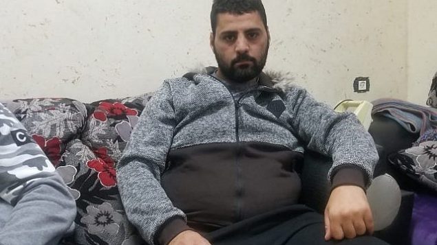 محمد العباسي (25 عاما) يجلس في غرفة المعيشة في منزل أحد أقربائه في سلوان، 23 ديسمبر، 2018. (Adam Rasgon/Times of Israel)