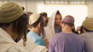 طلاب كلية ’بري هآرتس’ الدينية خلال الصلاة داخل اليشيفا في مستوطنة ريحليم (Screen capture/YouTube)