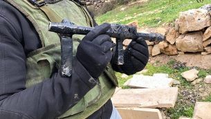جنود يصادرون أسلحة يُزعم أنها استُخدمت في هجوم إطلاق نار على مستوطنة ميغدال عوز في الضفة الغربية من قرية فلسطينية مجاورة، في يناير 2019. (Israel Defense Forces)