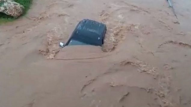 سيارة سحبتها فيضانات في نهر حيلازون في الجليل، 14 يناير 2019 (Northern District Fire and Rescue Services)