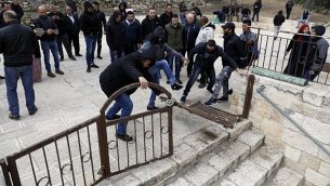 متظاهرون فلسطينيون يقومون بتحطيم وفتح بوابة مغلقة في المسجد الأقصى في القدس القديمة، 18 فبراير، 2019. (Ahmad Gharabli/AFP).