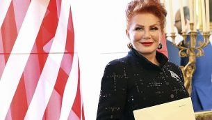 في هذه الصورة من يوم 6 سبتمبر، 2016، تقف جورجيت موسباكر إلى جانب العلم الأمريكي بعد حصولها على أوراق اعتمادها كسفيرة للولايات المتحدة لدى بولندا في وارسو. (AP Photo/Czarek Sokolowski, File)
