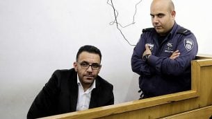شرطي إسرائيلي يحرس محافظ القدس التابع للسلطة الفلسطينية، عدنان غيث، خلال ظهوره أمام محكمة في أعقاب اعتقاله في القدس، 29 نوفمبر، 2018. (AP Photo/Mahmoud Illean)