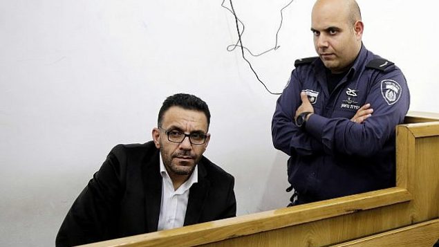 شرطي إسرائيلي يحرس محافظ القدس التابع للسلطة الفلسطينية، عدنان غيث، خلال ظهوره أمام محكمة في أعقاب اعتقاله في القدس، 29 نوفمبر، 2018. (AP Photo/Mahmoud Illean)