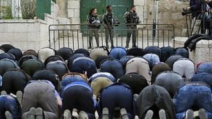 مصلون مسلمون فلسطينيون يصلون أمام حاجز بعد أن قامت شرطة حرس الحدود الإسرائيلية بإغلاق أحد مداخل الحرم القدسي في البلدة القديمة، 12 مارس، 2019. (Ahmad GHARABLI / AFP)