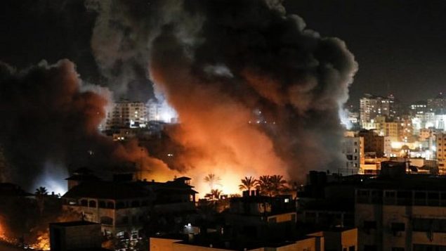 نار ودخان في محيط مبان في مدينة غزة خلال غارات إسرائيلية، 25 مارس، 2019.  (Mahmud Hams / AFP)