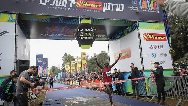 رونالد كيملي (33 عاما)، من كينيا، يجتاز خط النهاية في ماراثون القدس الدولي 2019 بتوقيت 02:18:47، 15 مارس، 2019. (Noam Revkin Fenton/Flash90)