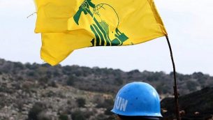 تظهر صورة مأخوذة من قرية ميس الجبل بجنوب لبنان في 16 ديسمبر 2018، جنديا من قوات الأمم المتحدة المؤقتة في لبنان (يونيفيل) يراقب الحدود بين لبنان وإسرائيل. على يمينه علم جماعة حزب الله الشيعية. (Mahmoud Zayyat/AFP)