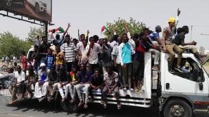 رجال سودانيون يحتفلون خلال مظاهرات في الخرطوم، 11 ابريل 2019 (AFP)