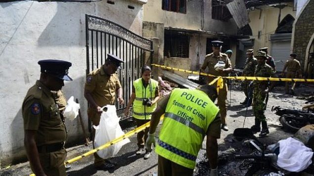 عناصر امن وعناصر شرطة يفحصون الحطام خارج كنيسة بعد تفجير في باتيكالوا، شرق سريلانكا، 21 ابريل 2019 (LAKRUWAN WANNIARACHCHI / AFP)