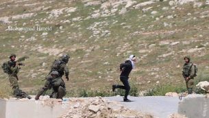 جندي اسرائيلي يلاحق مشتبه به فلسطيني اقناء محاولته القرار في قرية تقوع في الضفة الغربية، 18 ابريل 2019 (Mohammad Hmeid)