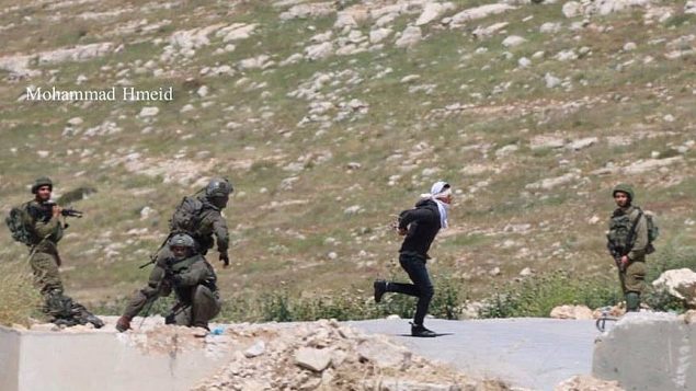 جندي اسرائيلي يلاحق مشتبه به فلسطيني اقناء محاولته القرار في قرية تقوع في الضفة الغربية، 18 ابريل 2019 (Mohammad Hmeid)