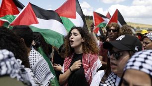 عرب من مواطني إسرائيل يرفعون الأعلام الفلسطينية خلال مشاركتهم في ’مسيرة العودة’ السنوية التي تجرى بالتزامن مع احتفال إسرائيل باستقلالها، بالقرب من مدينة أم الفحم في شمال البلاد، 9 مايو، 2019. (Ahmad Gharabli/AFP)