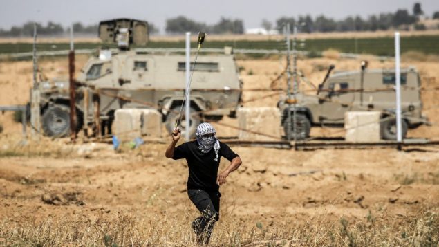 متظاهر فلسطيني يستخدم مقلاع لرشق حجارة باتجاه جنود اسرائيليين خلال مظاهرات يوم النكبة شرقي خان يونس، جنوب قطاع غزة، 15 مايو 2019 (Thomas COEX / AFP)