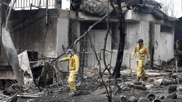 رجال اطفاء يفحصون منزلا تضرر نتيجة حريق جاء خلال موجة حر شديد في قرية ميفو مودعيم، في مركز اسرائيل، 24 مايو 2019 (JACK GUEZ / AFP)