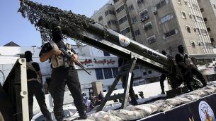 عناصر في ’سرايا القدس’، الجناح العسكري لحركة الجهاد الإسلامي الفلسطينية، خلال مسيرة مع مجسم صاروخ على شاحنة في 4 أكتوبر، 2018.  (AP Photo/Adel Hana)