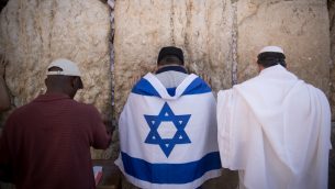 رجل يرتدي علم اسرائيل اثناء الصلاة في حائط المبكى في القدس القديمة، 17 سبتمبر 2017 (Yonatan Sindel/Flash90)