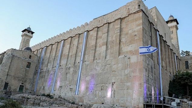 الأعلام الإسرائيلية ترفرف على أسوار الحرم الإبراهيمي (كهف البطاركة بحسب التسمية اليهودية) بمناسبة احتفال إسرائيل بيوم استقلالها ال71، في مدينة الخليل بالضفة الغربية، 8 مايو، 2019. (Gershon Elinson/Flash90)