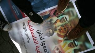 فلسطينيون يدوسون على لافتة تظهر صور ولي عهد ابو ظبي الشيخ محمد بن زايد، ولي العهد السعودي محمد بن سلمان، العاهل البحريني حند ال خليفة، سلطان قابوس العماني، رئيس الوزراء بنيامين نتنياهو، الرئيس الامريكي دونالد ترامب وصهره ومستشاره جاريد كوشنر، خلال مظاهرة ضد مؤتمر ’السلام الى الازدهر’ الامريكي في البحرين، في مدينة غزة، 24 يونيو 2019 (MOHAMMED ABED / AFP)